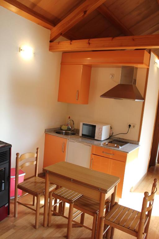 Una cocina con mesa y sillas y un microondas. en As Casas das Minas, en Zobra