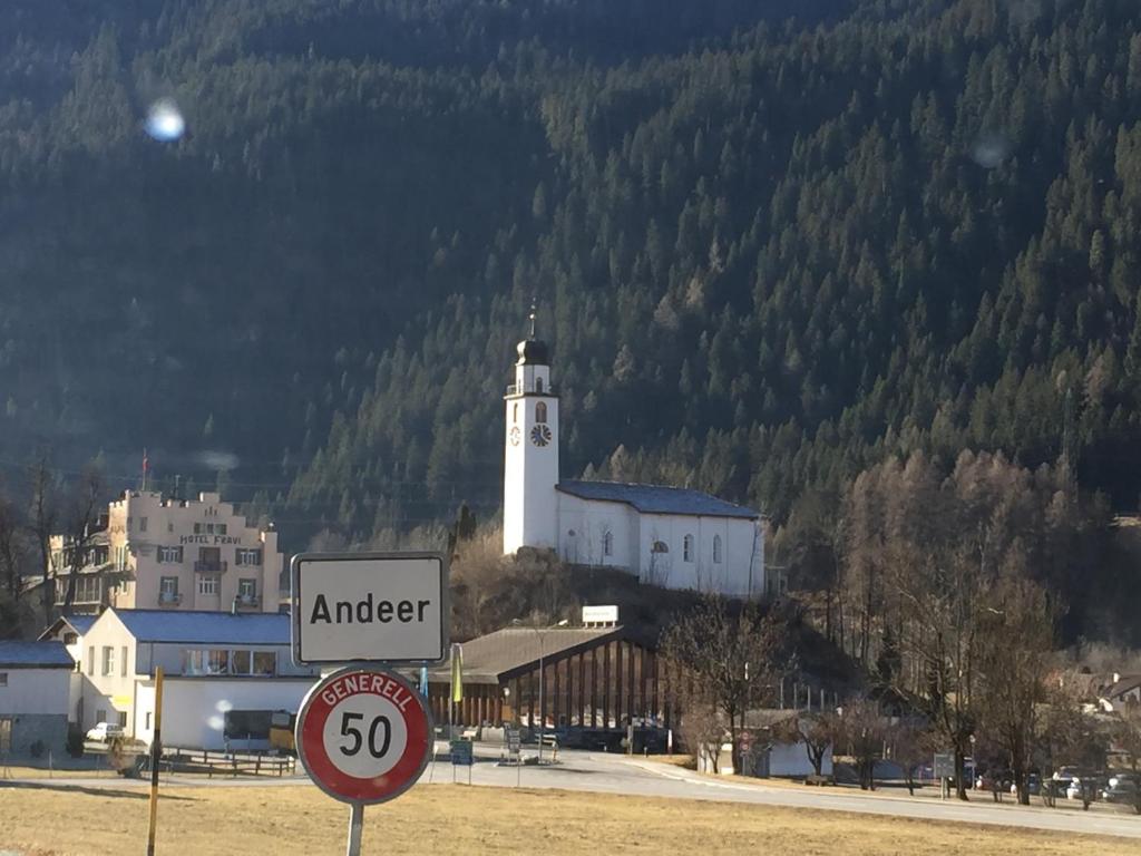 a street sign in front of a white building with a clock tower at Sut baselgia in Andeer