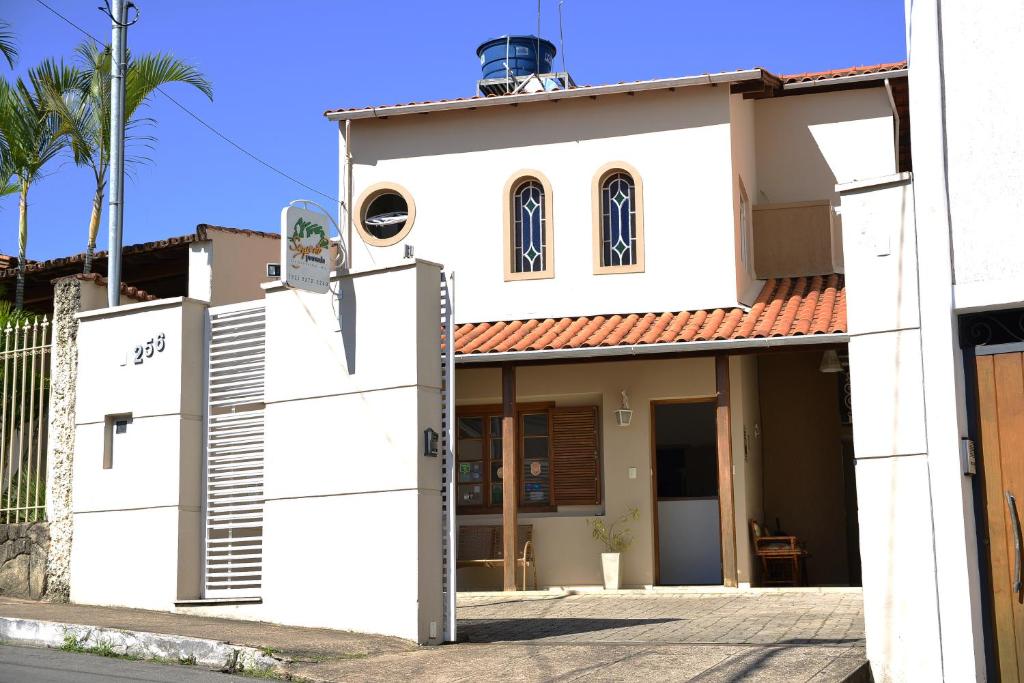 une maison blanche avec un toit rouge dans l'établissement Pousada Segredo, à São João del Rei