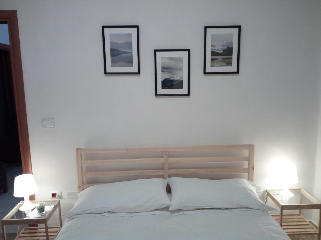 1 dormitorio con 1 cama con 3 cuadros en la pared en Montesanto 116, en Cosenza