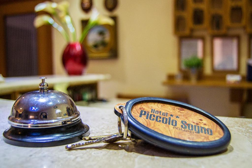 łańcuszek na klucz siedzący na stole w obiekcie Hotel Piccolo Sogno w mieście Pompeje