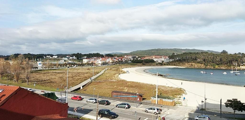 uma vista para uma praia com barcos na água em Atico a pie de playa Portonovo em Sanxenxo