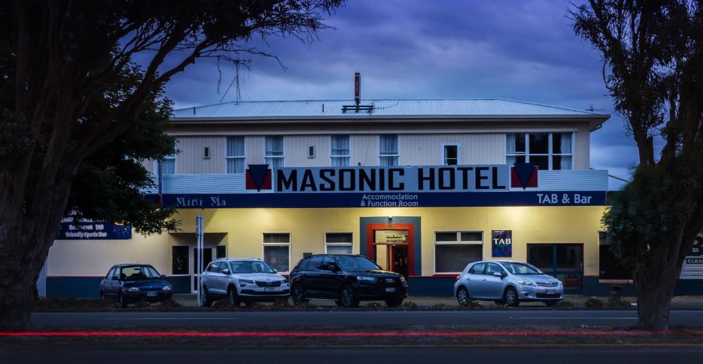 a building with cars parked in front of it at Masonic Hotel in Palmerston North