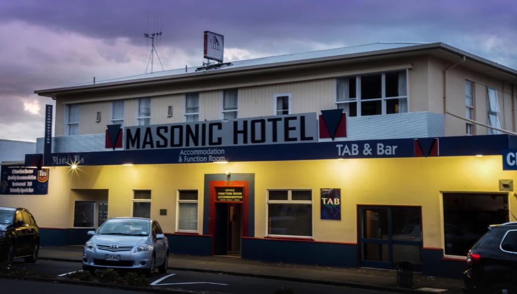 een masino hotel met een auto voor het hotel bij Masonic Hotel in Palmerston North