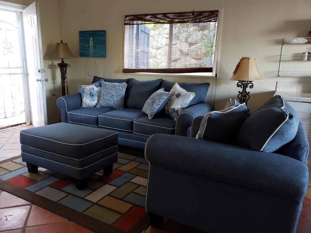 un soggiorno con divano blu e sedia di The Cottage at Villa Indigo a Charlotte Amalie