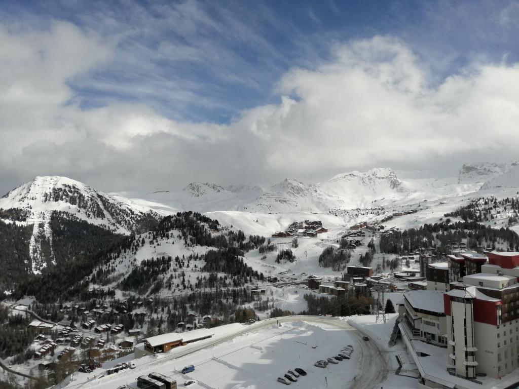 a view of a snowy mountain range with a city at Plagne AIME 2000 Ski Apartments in Aime-La Plagne