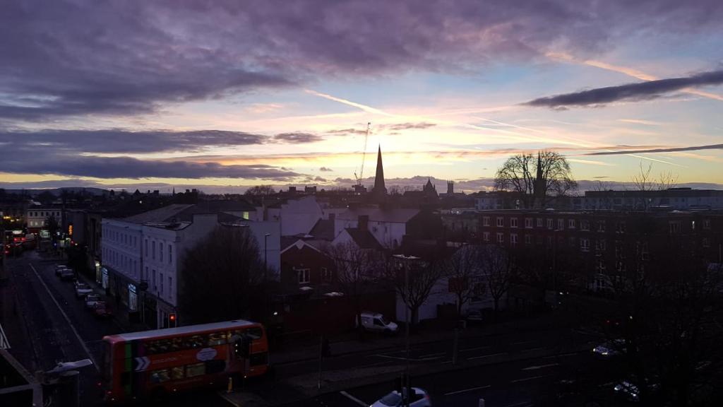a view of a city at sunset with a church at Central Penthouse with Hot Tub & Views 23 in Cheltenham