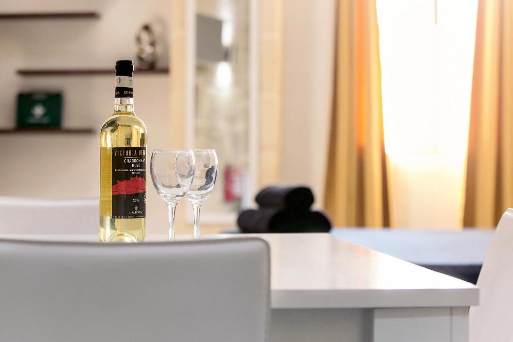 una bottiglia di vino seduta su un tavolo con un bicchiere di vino di Sqaq Numru 1 Accomodation a Rabat