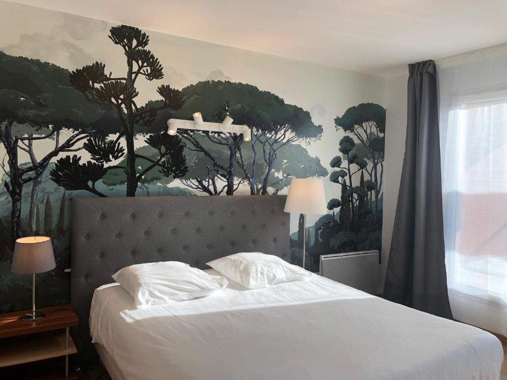 a bedroom with a bed with a painting on the wall at Villa Val Senart 1ere Avenue in Quincy-sous-Sénart
