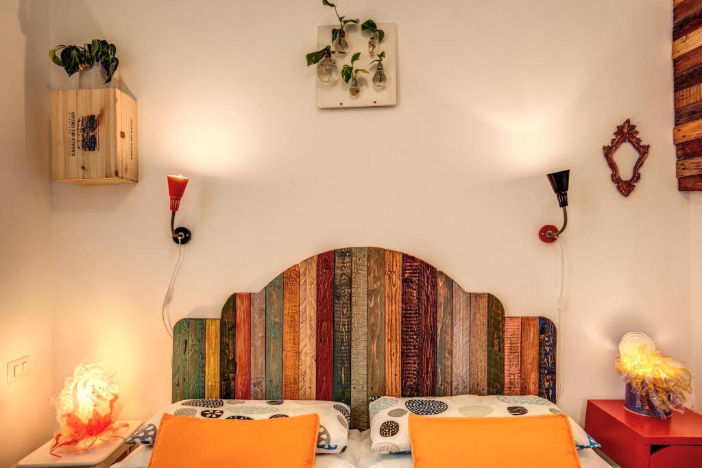 1 dormitorio con 1 cama y 2 sillas de color naranja en Urban Chic Studio - by BRAVE, en Roma