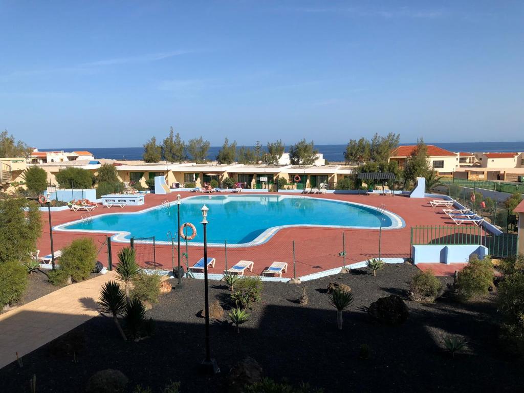 een groot zwembad in een resort met stoelen bij Fuerteventura Resort Bouganville in Costa de Antigua
