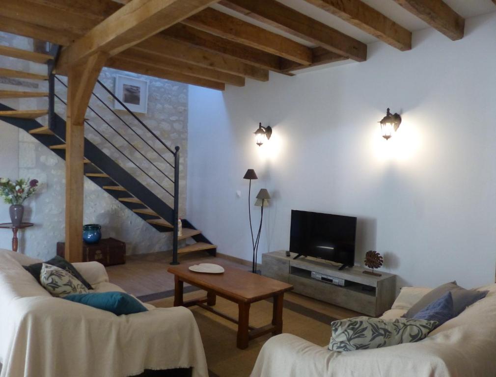 a living room with two couches and a tv at La maison de Joëlle in Châteauvieux