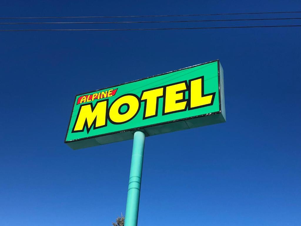 a sign for a motel on top of a pole at Alpine motel in Rocky Mountain House