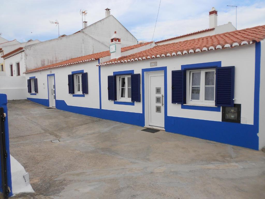 a blue and white building with black shutters at Moradias Ode in Odeceixe