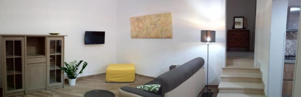 a living room with a couch and a yellow stool at Ancilinas House in Castellammare del Golfo