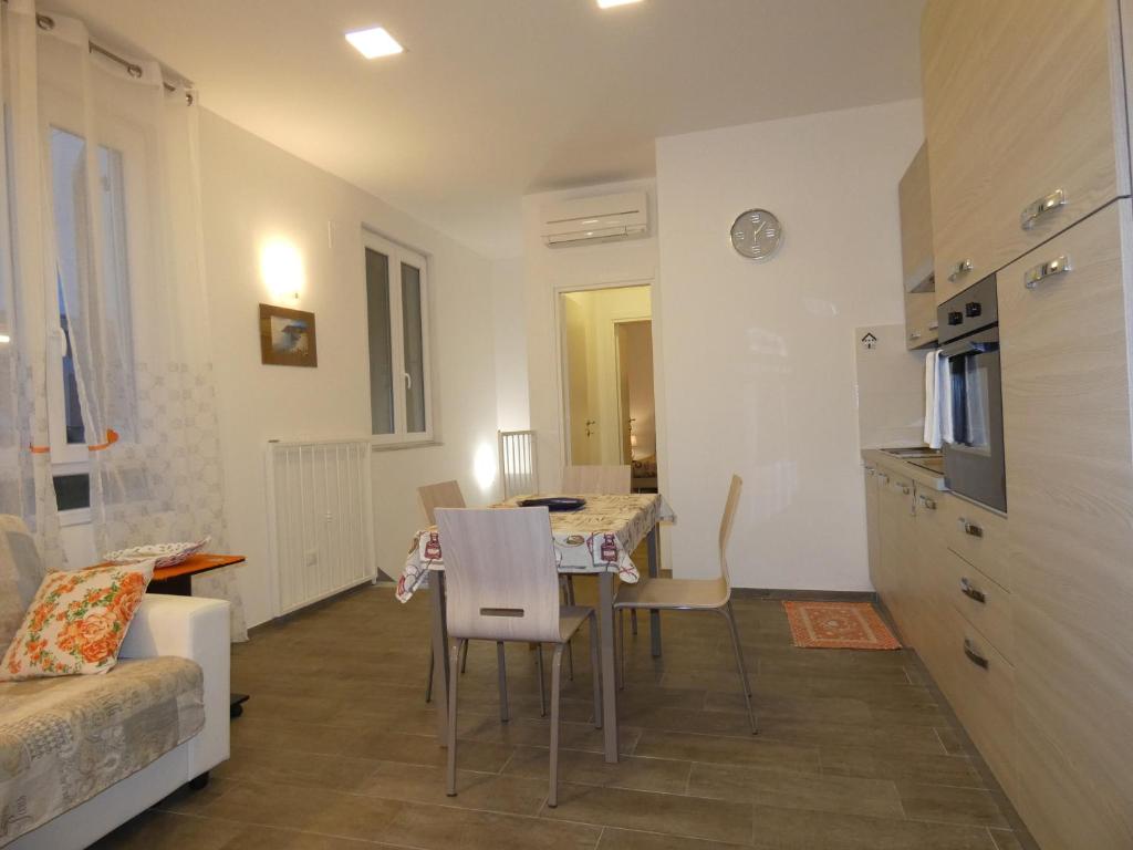 cocina y sala de estar con mesa y sillas en Loft La Conchiglia, en La Spezia