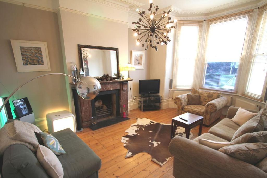 a living room with a couch and a fireplace at SW4 Apartment Clapham Common in London