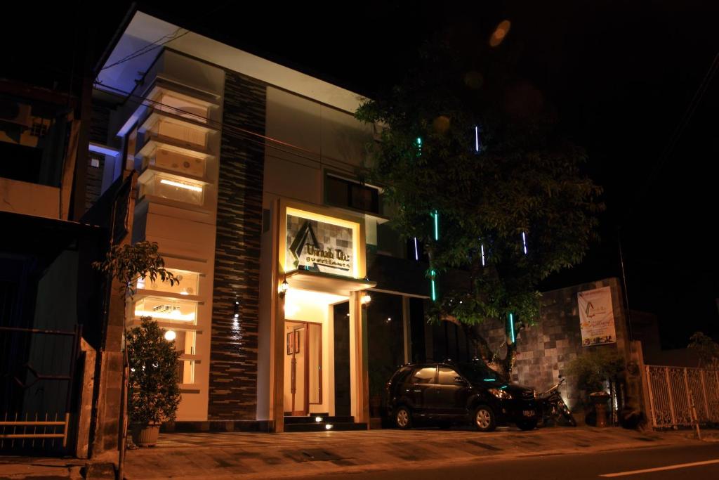 a car parked in front of a building at night at Omah Qu Guesthouse Malioboro in Yogyakarta
