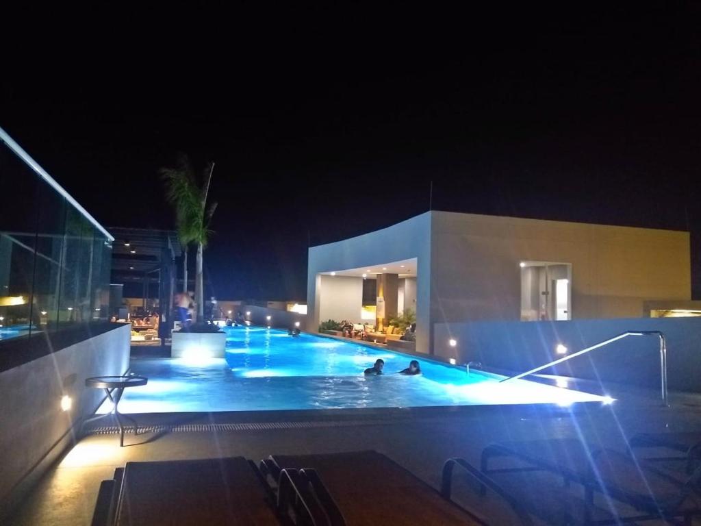 una piscina por la noche con dos personas. en Reserva del mar - Ocean View, en Santa Marta