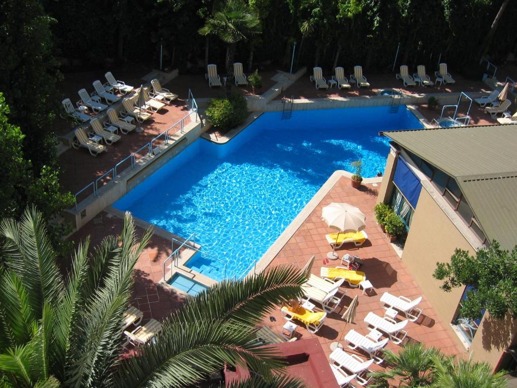 una vista sul soffitto di una piscina con sedie e ombrelloni di Aldrovandi Residence City Suites a Roma