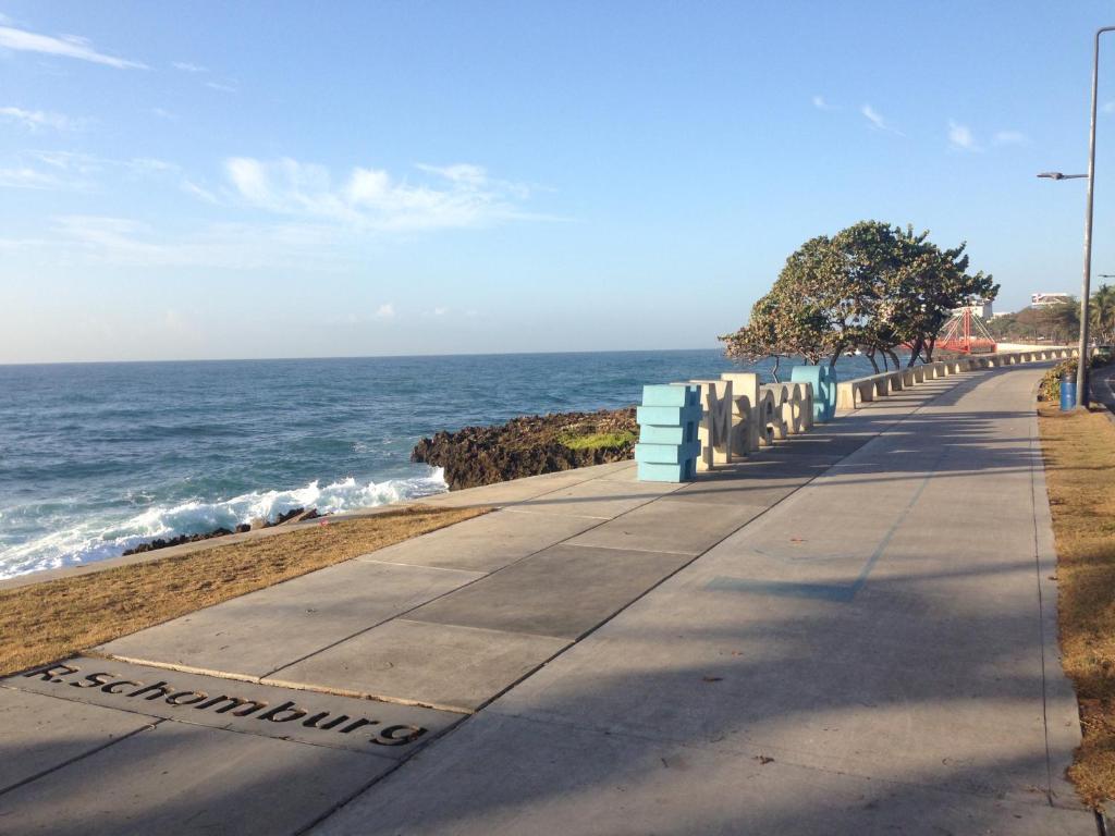 a sidewalk next to the ocean on a beach at Caribbean Seaview apart Malecon Santo Domingo in Santo Domingo
