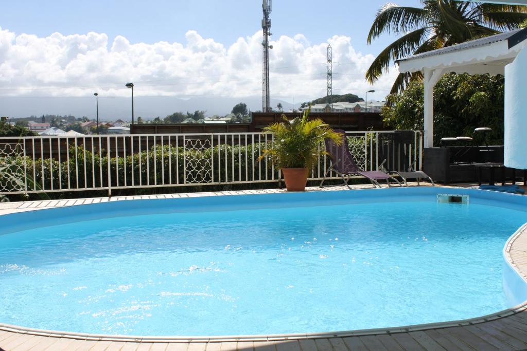 a large blue swimming pool with a fence at Lauraym2 in Baie-Mahault