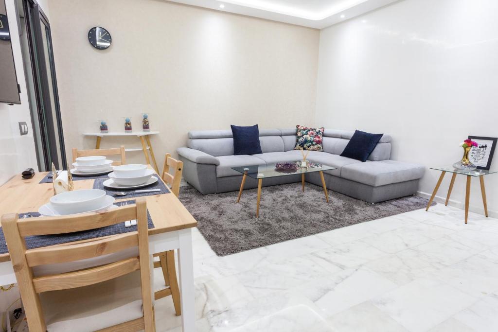 uma sala de estar com um sofá e uma mesa em Miramar Residence Beach em Mohammedia