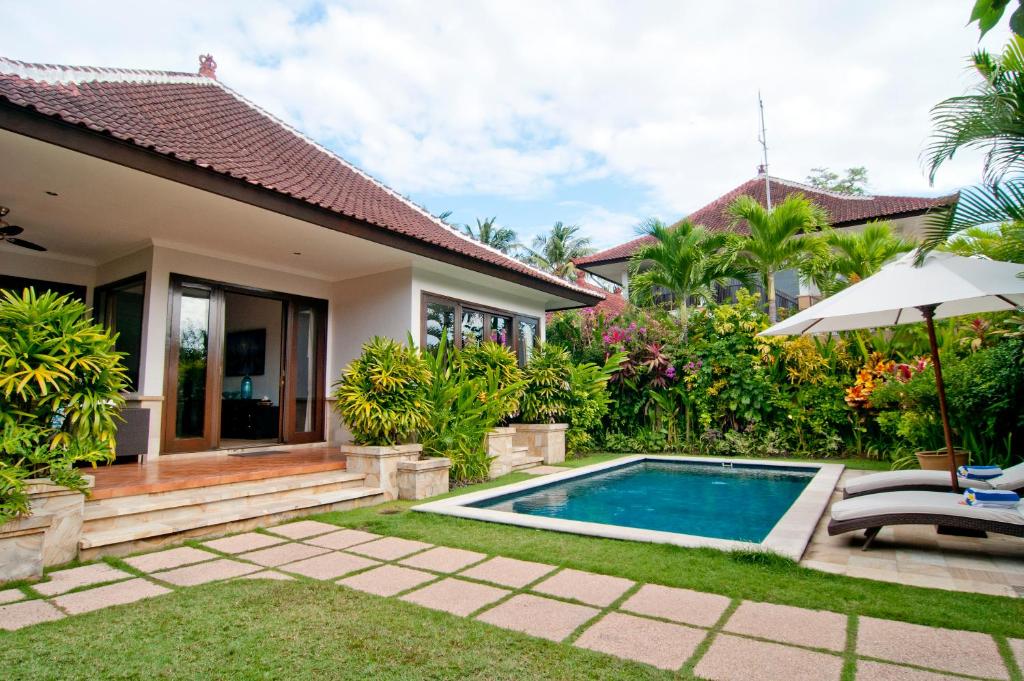 a villa with a swimming pool and a house at Villa Selaras in Sanur