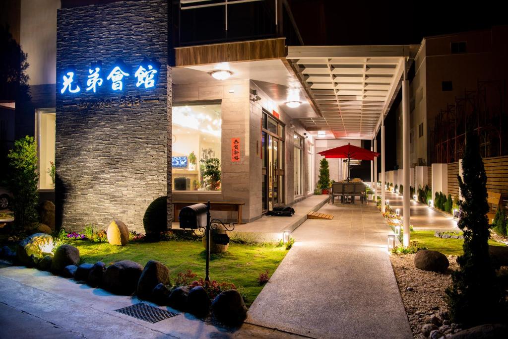 馬公市的住宿－兄弟會館民宿，一座建筑物,晚上在建筑物的一侧有标志