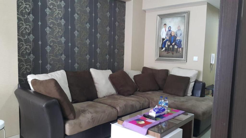 a living room with a brown couch and a table at The Sixth Room in Yogyakarta