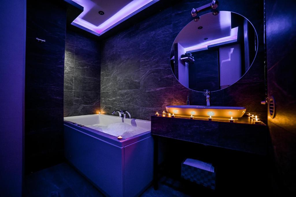 baño con bañera y lavabo con luces en Sinergija, en Belgrado