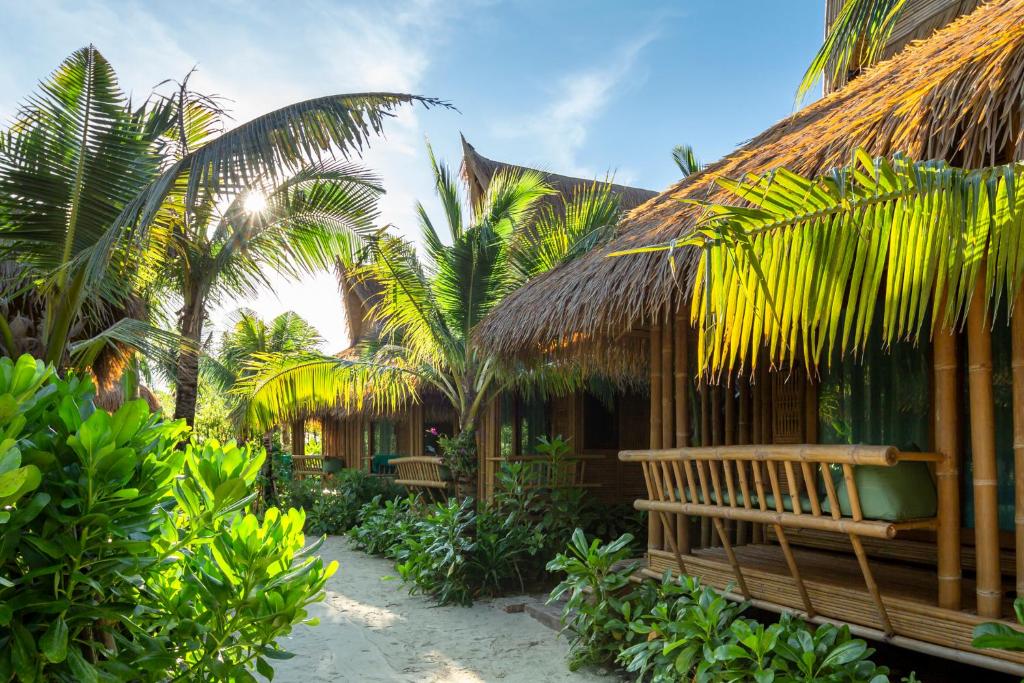 皮皮岛Phi Phi CoCo Beach Resort的一个带长凳和一些棕榈树的度假村