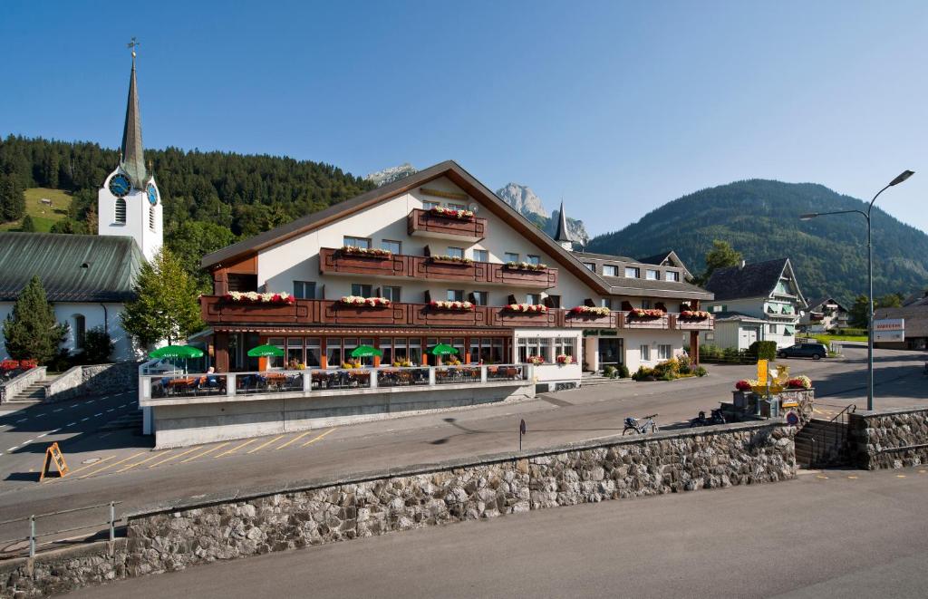 ein großes Gebäude in einer Stadt mit Kirche in der Unterkunft Hotel Sonne in Wildhaus