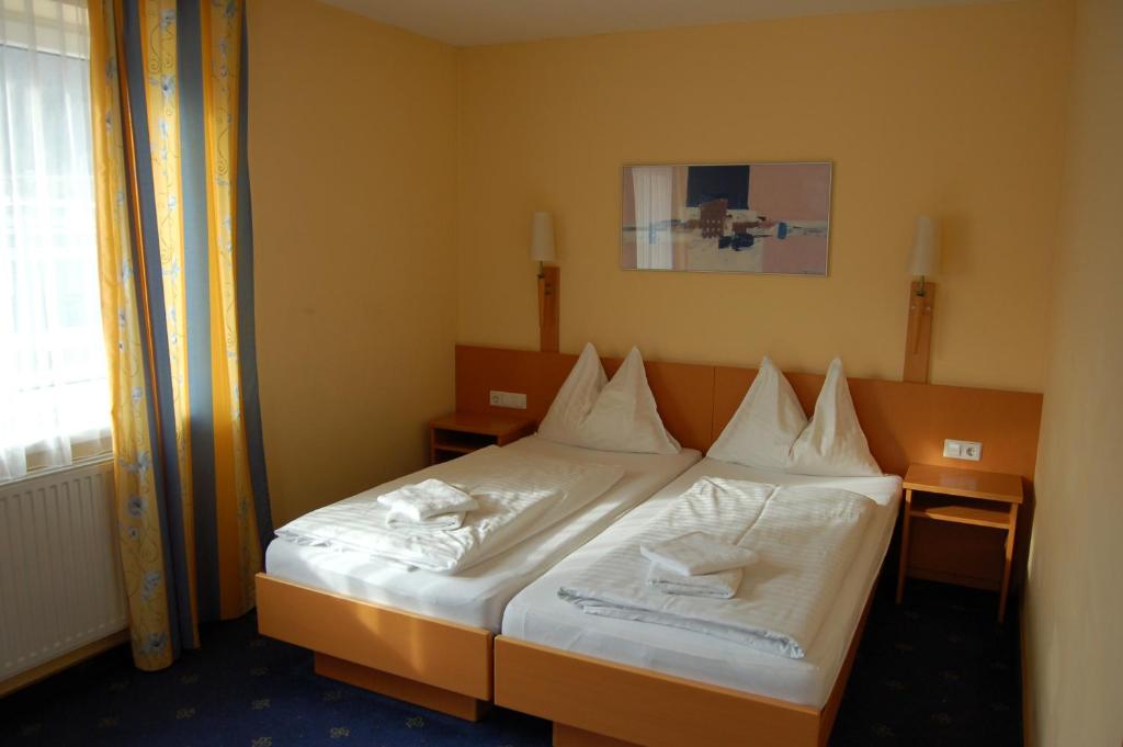 a bedroom with a bed with white sheets and pillows at Gästehaus St.Michael in Sankt Michael in Obersteiermark