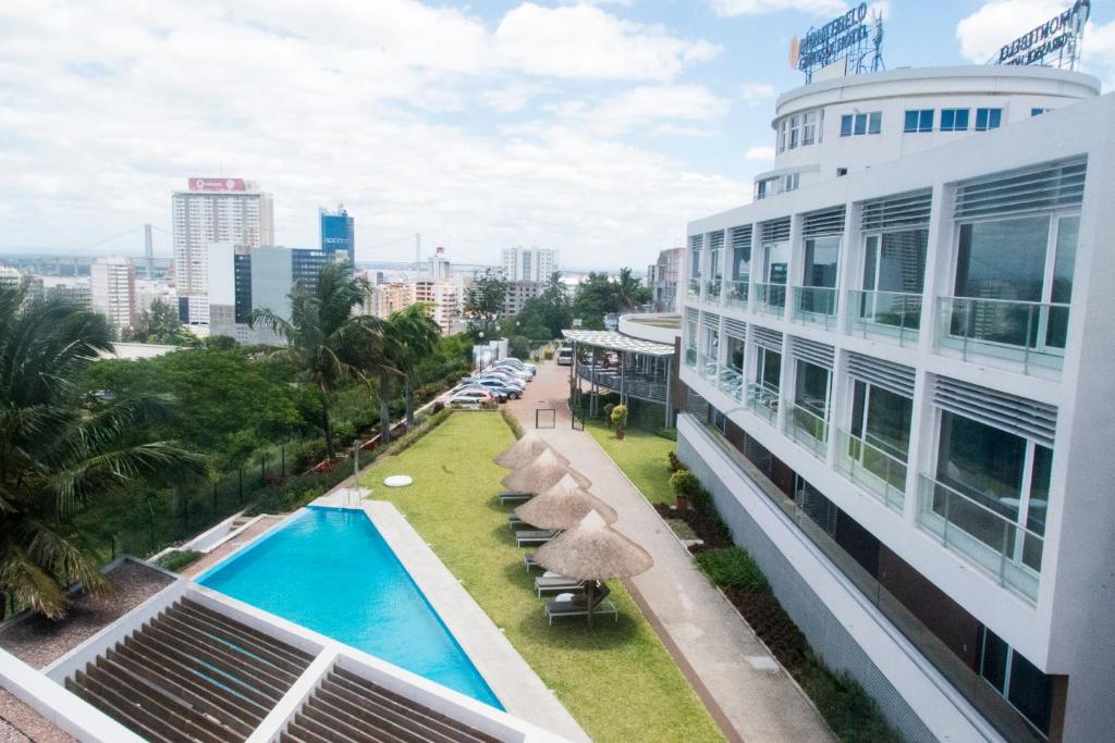 einen Blick auf den Pool vom Balkon eines Gebäudes in der Unterkunft Montebelo Girassol Maputo Hotel in Maputo