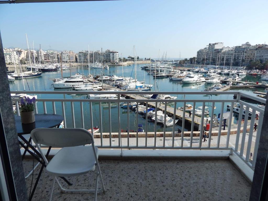balcón con vistas a un puerto deportivo con barcos en ATHENS RIVIERA SEA VIEW APARTMENT, en Pireo