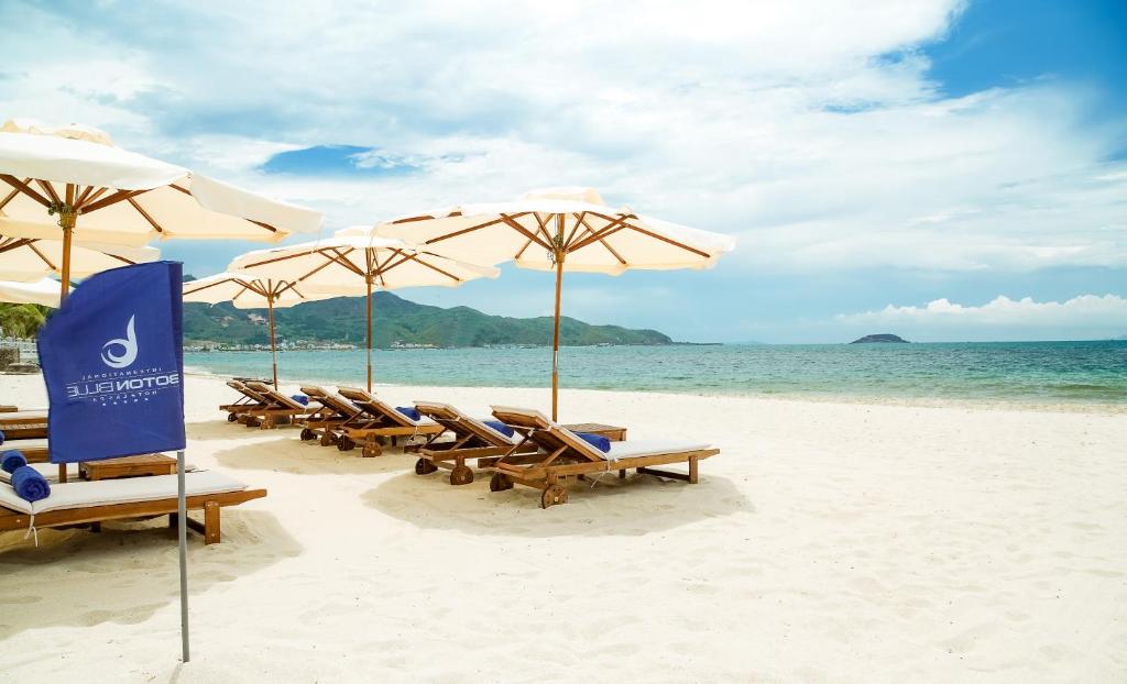 a group of chairs and umbrellas on a beach at Boton Blue Hotel & Spa in Nha Trang