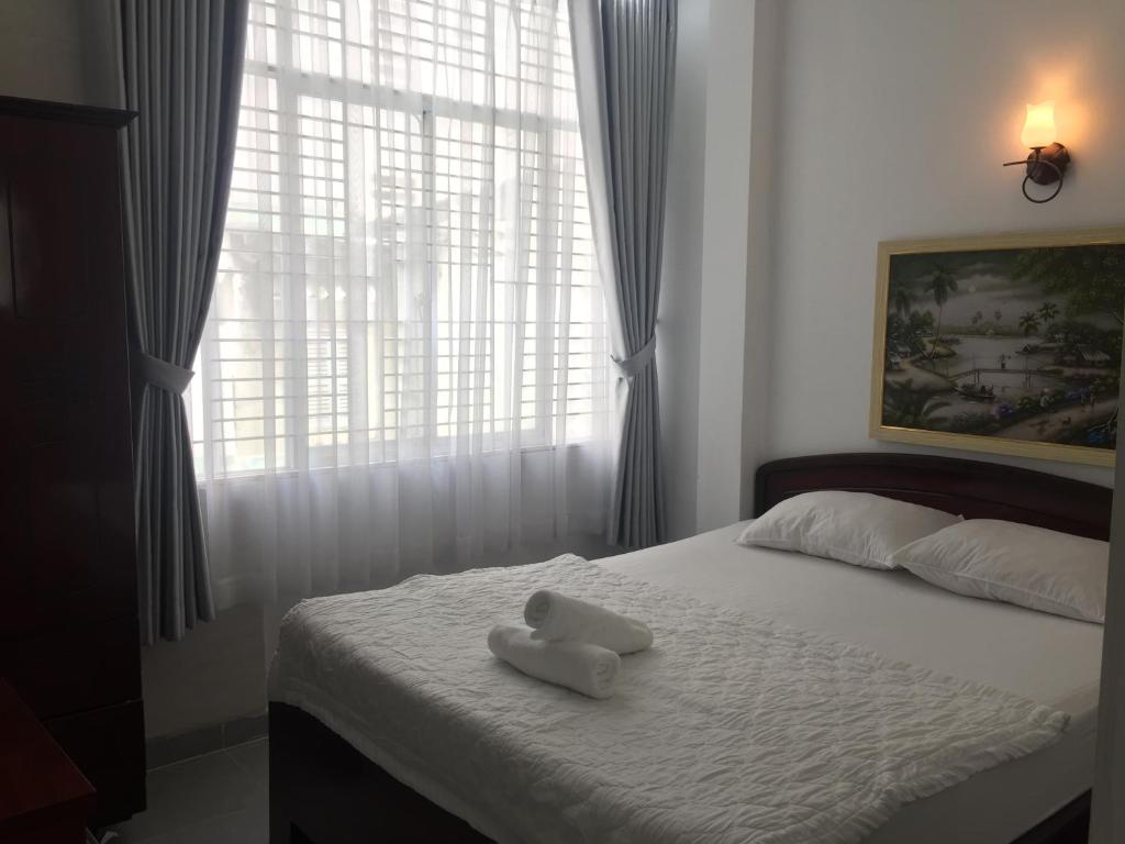 a bed with a white stuffed animal sitting on it at Vy Khanh Guesthouse in Ho Chi Minh City