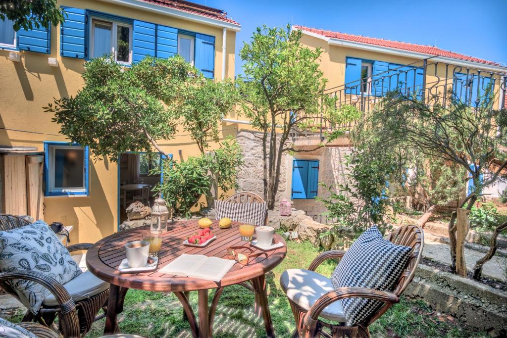 a patio with a table and chairs and a building at ECO Aparthotel The Dreamers's Club in Lumbarda