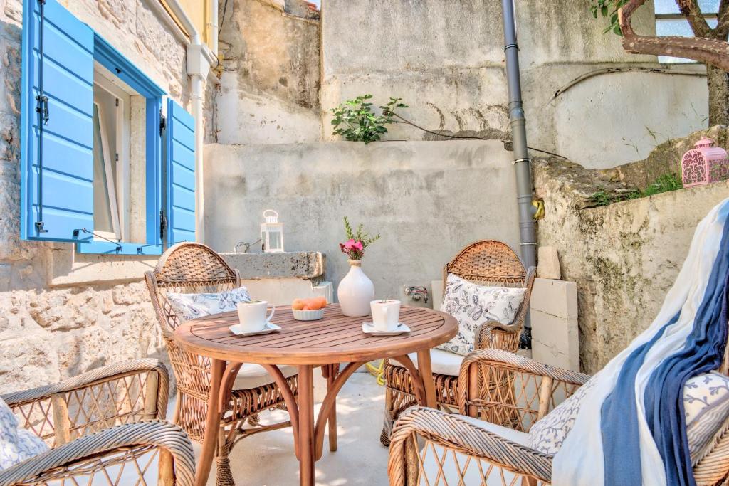 a wooden table and chairs on a patio at ECO Aparthotel The Dreamers's Club in Lumbarda