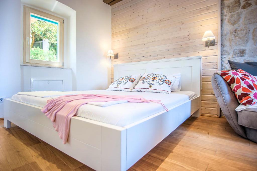 a bedroom with a white bed and a window at ECO Aparthotel The Dreamers's Club in Lumbarda