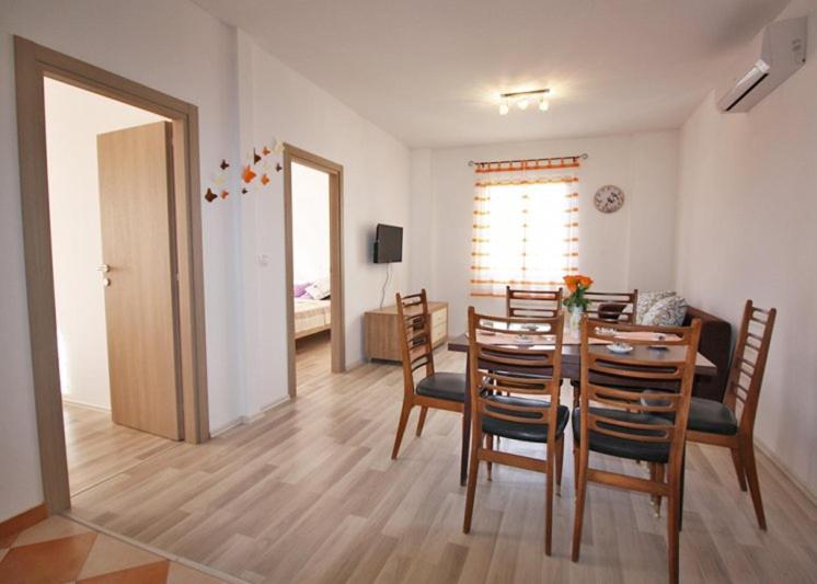 a kitchen and dining room with a table and chairs at Apartman Petra in Fažana