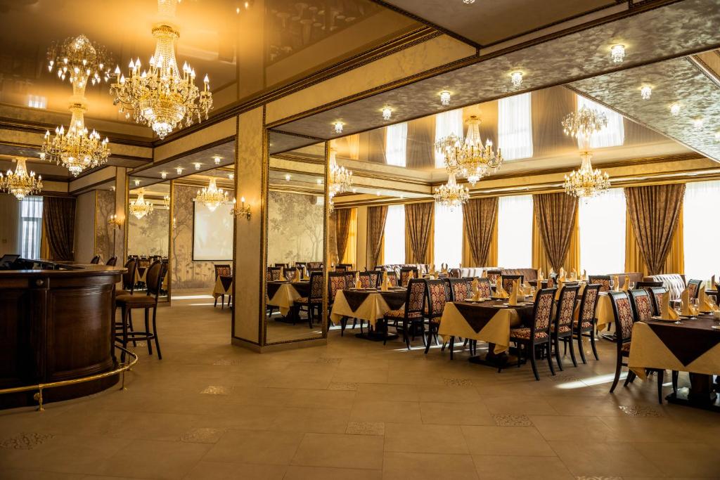 a dining room with tables and chairs and chandeliers at Baza Otdykha Kazaki in Aleksandrovka