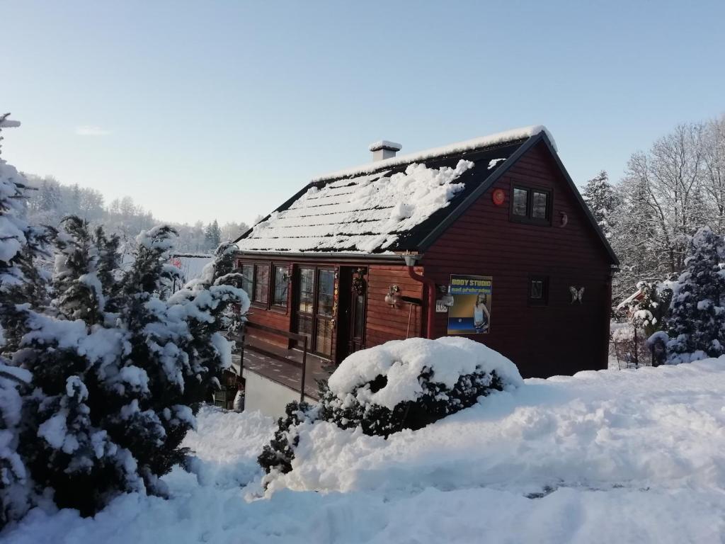 een rode hut met sneeuw op het dak bij Chata v Jizerských Horách in Liberec