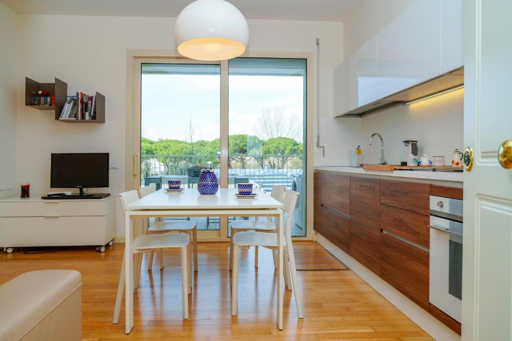 cocina con mesa, sillas y ventana en Appartamento Il Castello en Rímini