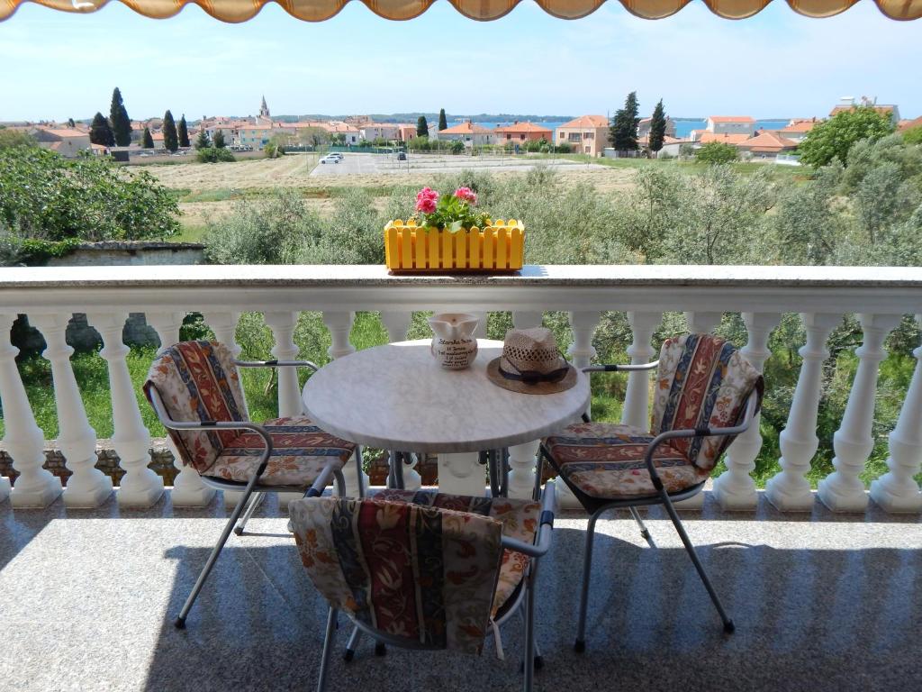 un tavolo e sedie su un balcone con vista di MARILENA a Fažana