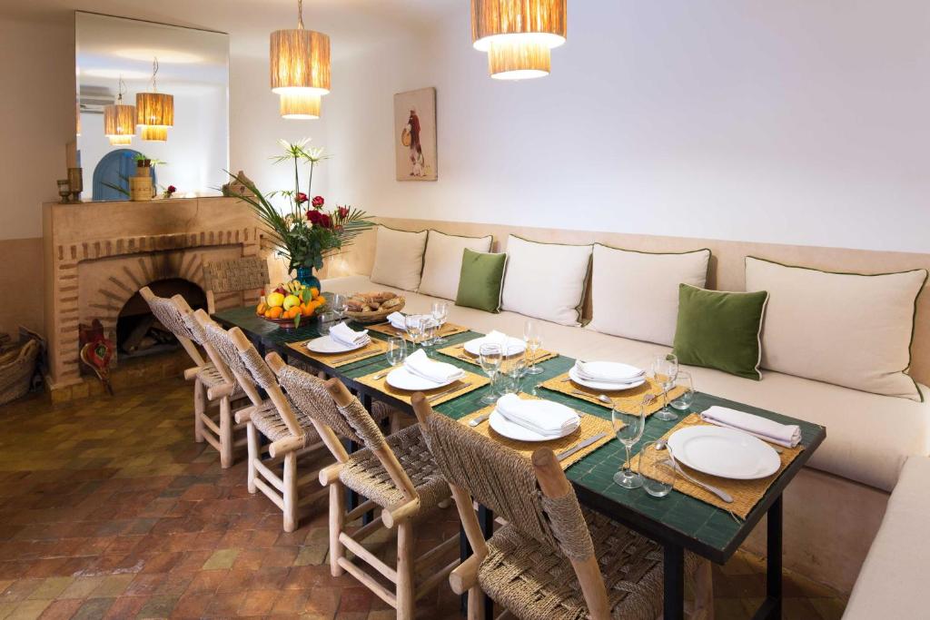 une salle à manger avec une table et un canapé dans l'établissement Riad Assala, à Marrakech