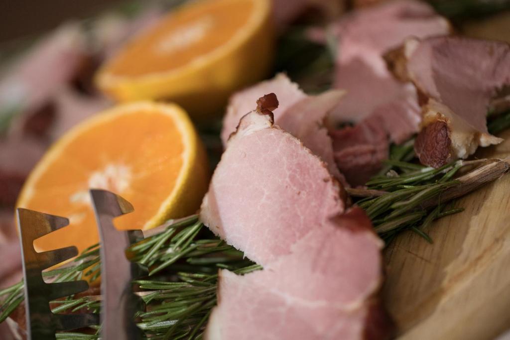 a cutting board with ham and orange slices on it at Aktaion Resort in Gythio
