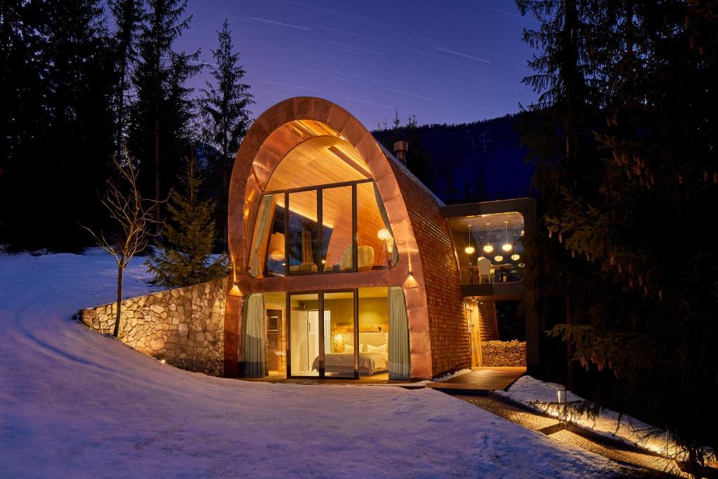 ein Haus mit einer gewölbten Tür im Schnee in der Nacht in der Unterkunft Mi Chalet in Stern