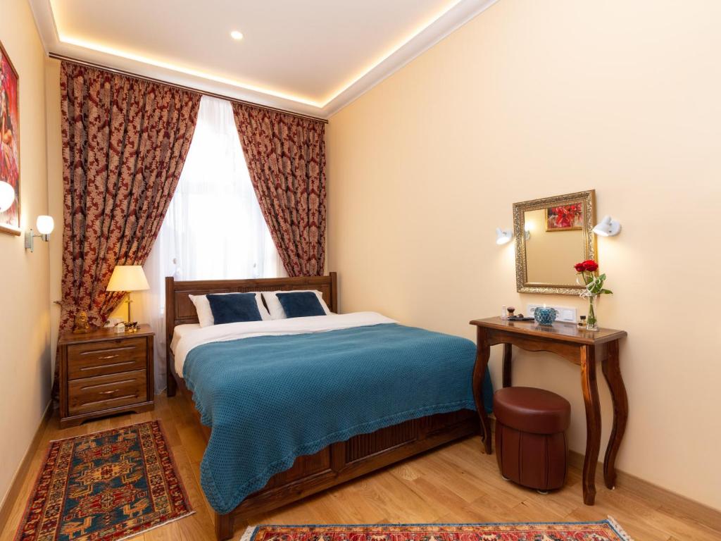 een slaapkamer met een bed, een spiegel en een raam bij Lviv Suites at Pidmurna st. 20 in Lviv